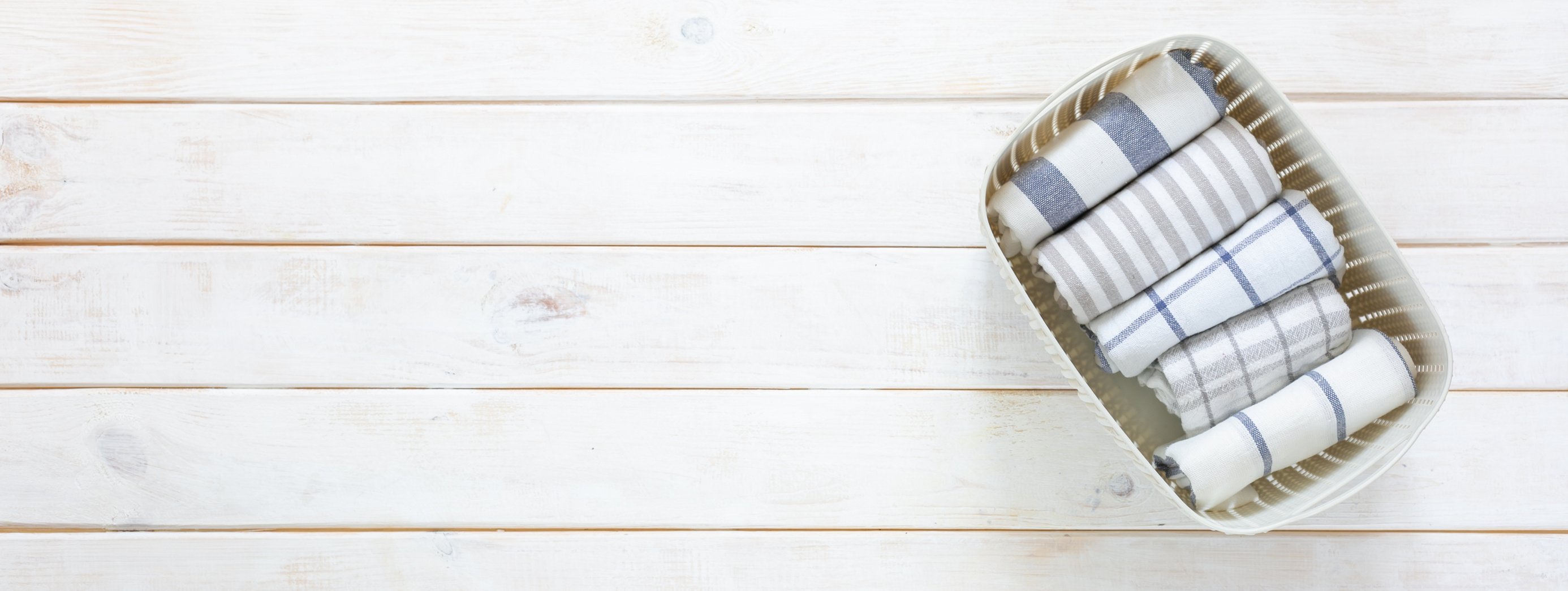 Marie Kondo Tidying Concept - Folded Kitchen Linens in White Basket